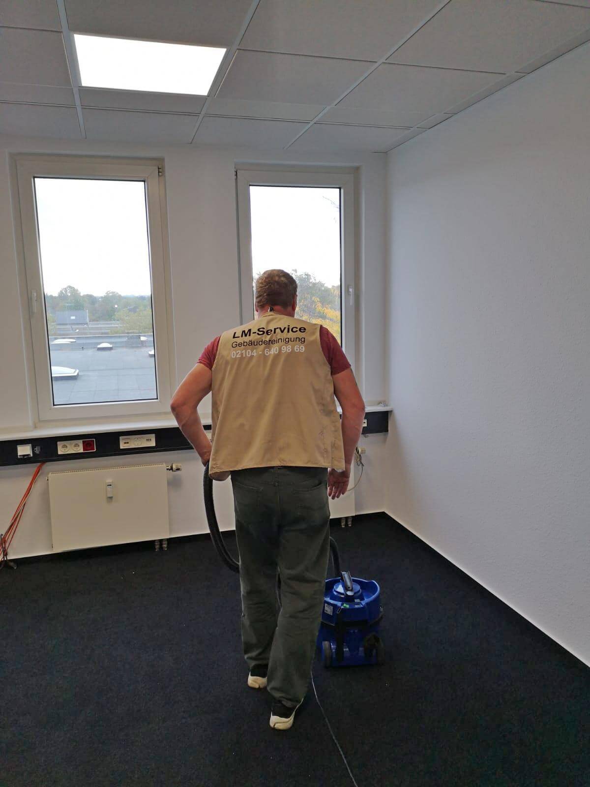 ein Mann reinigt einen Teppich im Büro ein Mann reinigt einen Teppich im Büro
